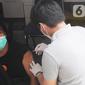 Petugas Dinas Kesehatan Kota Bogor menyuntikkan vaksin Covid-19 dosis ketiga (booster) di mobil vaksinasi keliling, Terminal Penumpang Tipe A Baranangsiang, Kota Bogor, Sabtu (23/4/2022). Pemkot Bogor menyediakan sentra vaksinasi Covid-19 dosis booster untuk pemudik Lebaran 2022 di terminal tersebut sebagai salah satu upaya pemenuhan syarat perjalanan sekaligus untuk menekan laju penularan Covid-19 di tengah tingginya mobilitas masyarakat. (merdeka.com/Arie Basuki)