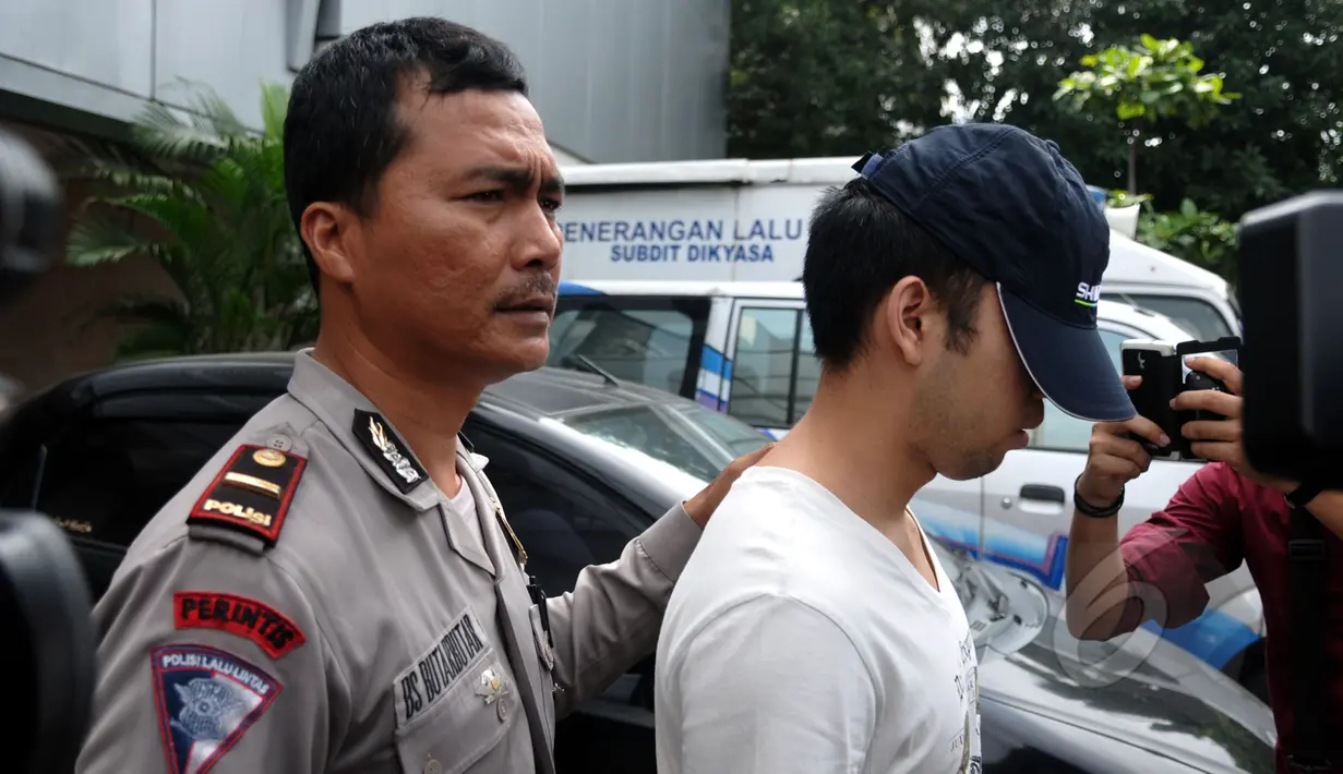 Tersangka kasus kecelakaan maut di Pondok Indah, Christopher Daniel Sjarif dikawal petugas saat hendak meninggalkan Dirlantas Polda Metro dibawa ke tahanan Kejaksaan Negeri Jakarta Selatan, Kamis (16/4/2014). (Liputan6.com/Johan Tallo)