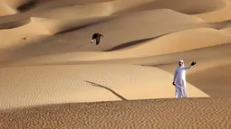 Emirati Ali Mansouri melatih elang di Gurun Liwa,Abu Dhabi, Uni Emirat Arab, Sabtu (9/1/2021). Elang memainkan peran penting dalam kehidupan Badui (orang Arab nomaden). (Karim SAHIB/AFP)