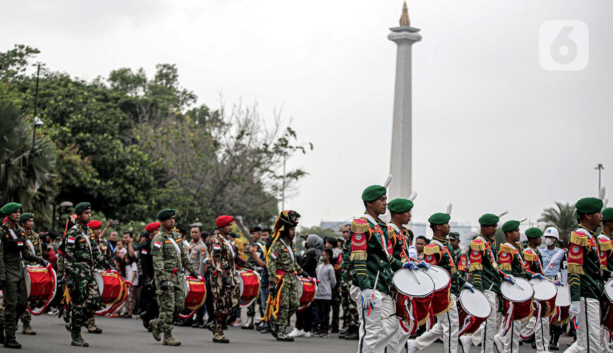 Pasukan TNI menampilkan pertunjukan marching band di depan Istana Merdeka, Jakarta, Rabu (5/10/2022). Kegiatan yang diikuti oleh seluruh kesatuan jajaran TNI ini dalam rangka menyambut HUT ke-77 TNI. (Liputan6.com/Faizal Fanani)