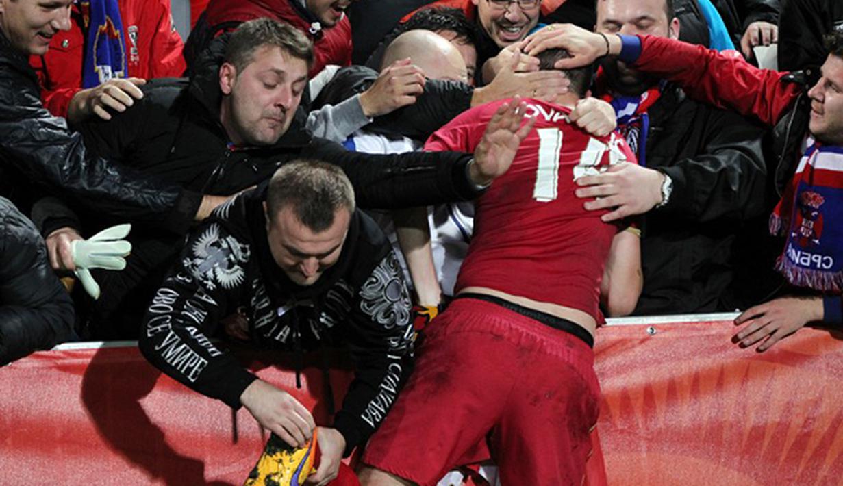 Pemain Serbia Vukasin Jovanovic melakukan selebrasi dengan para suporter setelah berhasil mengalahkan Brasil pada Final Piala Dunia U-20. (AFP PHOTO / Michael Bradley)