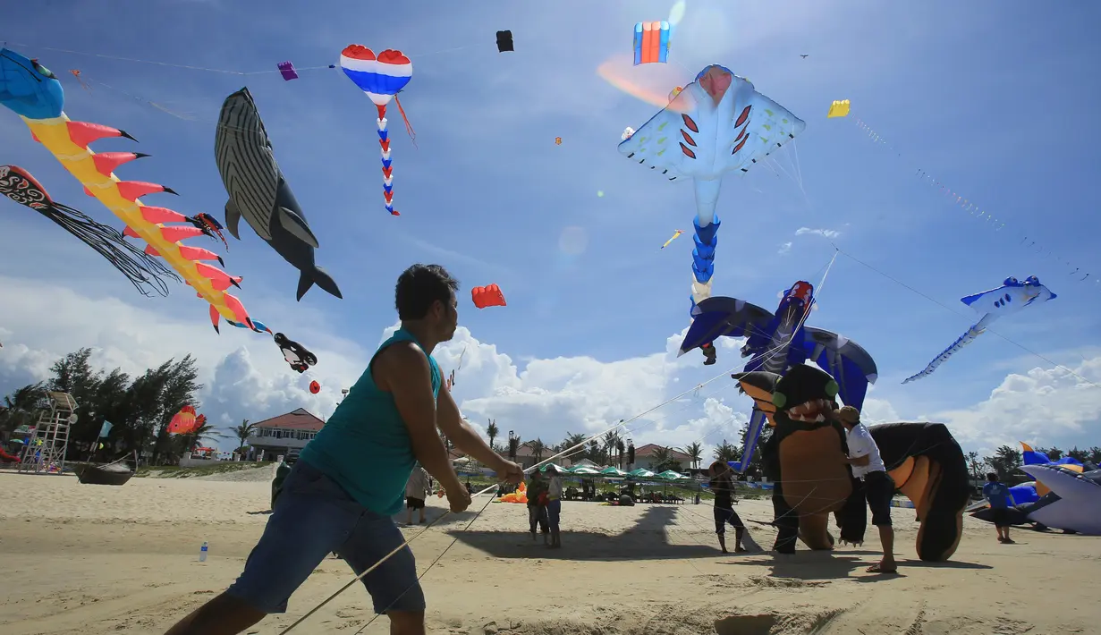 Seorang peserta menerbangkan layang-layangnya diatas pantai Tam Thanh selama Festival Internasional Kite di Quang Nam, Vietnam (11/6). Dalam festival ini, pengrajin menunjukan keterampilan membuat, serta menerbangkan layang-layangnya. (AP Photo/Hau Dinh)