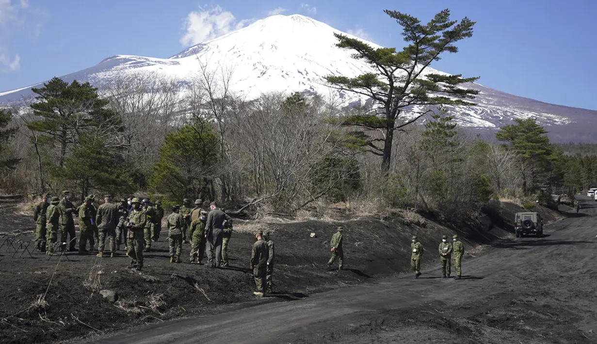 Pasukan berkumpul dengan Gunung Fuji yang ikonik pada latar belakang saat latihan operasi gabungan helikopter militer antara Pasukan Bela Diri Darat Jepang (JGSDF) dan Marinir AS di Higashi Fuji, Gotemba, Jepang, Selasa (15/3/2022). (AP Photo/Eugene Hoshiko)