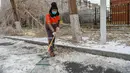 Seorang petugas kebersihan menyingkirkan es dan salju dari jalanan perkotaan di Changchun, Provinsi Jilin, China timur laut, pada 19 November 2020. Hujan lebat dan salju yang jarang terjadi disertai angin kencang melanda Changchun pada 18 dan 19 November. (Xinhua/Zhang Nan)