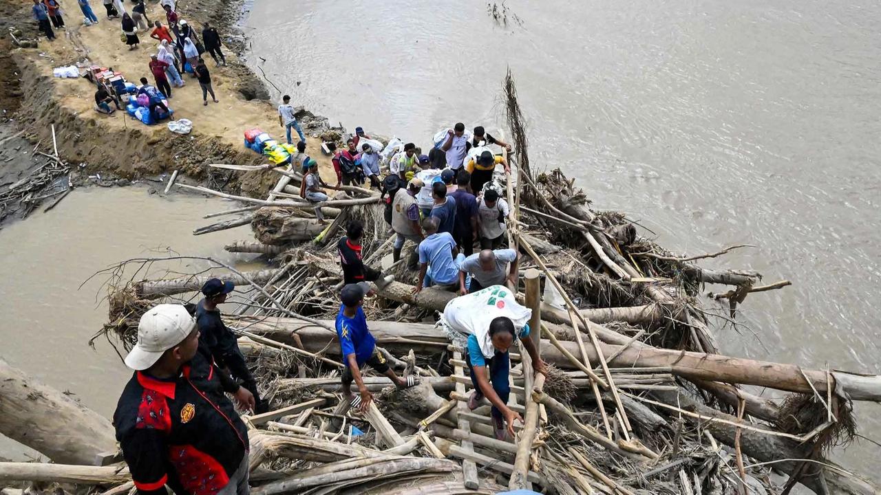 FOTO: Warga Memanjat Puing Kayu Demi Menyeberangi Sungai Peusangan