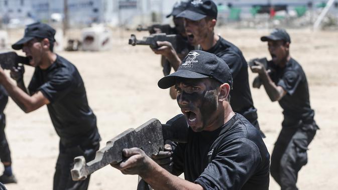 Sejumlah kadet Palestina berlatih menembak dengan militer Hamas, Brigade Ezzedin al-Qassam, di Kota Gaza (20/7/2019). Serangkaian tes militer pun harus dilakukan para kadet yang dimulai dari uji fisik, ketangkasan hingga menembak. (AFP Photo/Mahmud Hams)