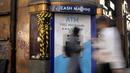 Pejalan kaki melewati mesin ATM di Oxford Street di London, Rabu (15/2/2023). Tingkat inflasi Inggris turun untuk bulan ketiga berturut-turut pada Januari, meningkatkan optimisme bahwa krisis biaya hidup telah memuncak dan harga akan turun tajam akhir tahun ini. (AP Photo/Kirsty Wigglesworth)