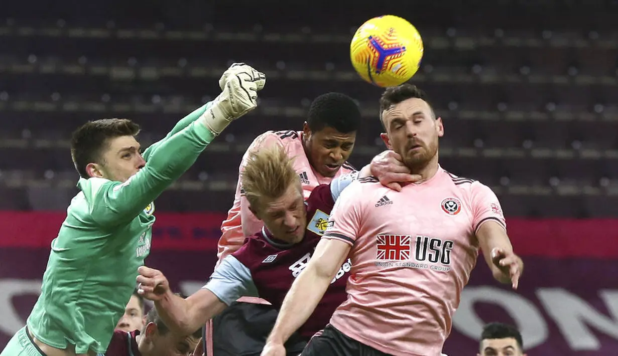 Kiper Burnley, Nick Pope, meninju bola saat melawan Sheffield United pada laga Liga Inggris di Stadion Turf Moor, Selasa (29/12/2020). Burnley menang dengan skor 1-0. (Barrington Coombs/Pool via AP)