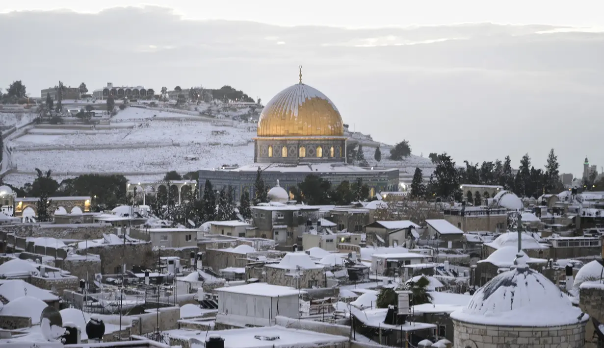 Salju menutupi Masjid Kubah Batu di kompleks Masjid Al Aqsa di Kota Tua Yerusalem, Kamis (27/1/2022). Hujan salju yang jarang melanda sebagian wilayah Israel dan Tepi Barat, menutup sekolah dan bisnis. (AP Photo/Mahmoud Illean)