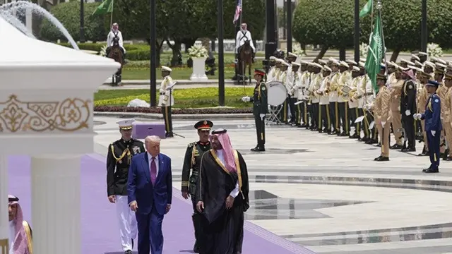 Presiden Amerika Serikat Donald Trump berjalan bersama Putra Mahkota Arab Saudi Mohammed bin Salman selama upacara penyambutannya di Riyadh, Selasa (13/5/2025).
