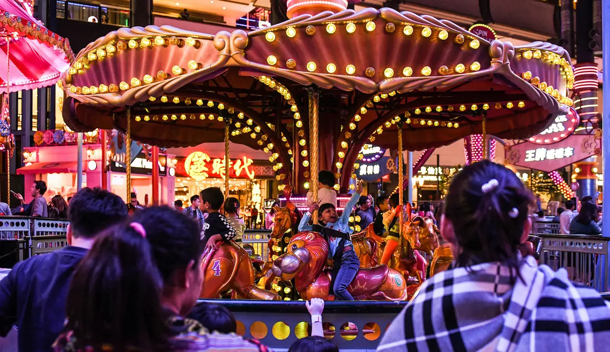 Sejumlah anak bermain wahana kuda putar di Skytropolis Funland di resor Genting Highlands, Kuala Lumpur, Malaysia (30/6/2019). Cuaca di Genting Highlands relatif sejuk dengan temperatur tidak lebih dari 30 °C dan jarang turun di bawah 15 °C setiap tahunnya. (AFP Photo/Mohd Rasfan)