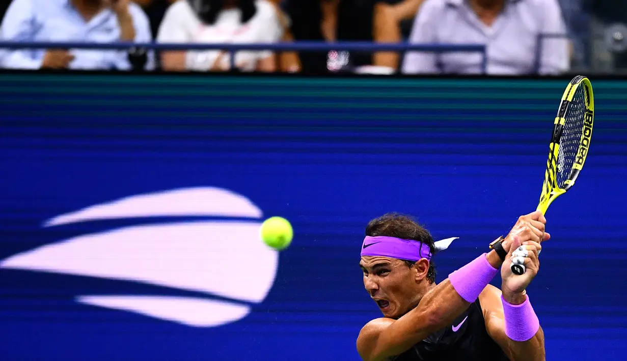 Petenis Spanyol, Rafael Nadal memukul bola ke arah lawannya petenis Argentina, Diego Schwartzman  pada babak perempat final AS Terbuka 2019  di Arthur Ashe Stadium, Rabu (4/9/2019). Nadal berhasil melangkah ke semifinal dalam pertarungan tiga set dengan skor 6-4, 7-5, dan 6-2. (Johannes EISELE/AFP)