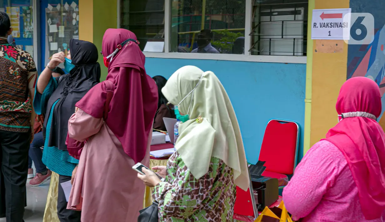 Para guru antre untuk menjalani vaksinasi COVID-19 di SMA 70, Jakarta, Rabu (25/2/2021). Sebanyak 600 orang dari profesi guru, tenaga kependidikan, dan dosen akan divaksin COVID-19 hari ini. (Liputan6.com/Faizal Fanani)