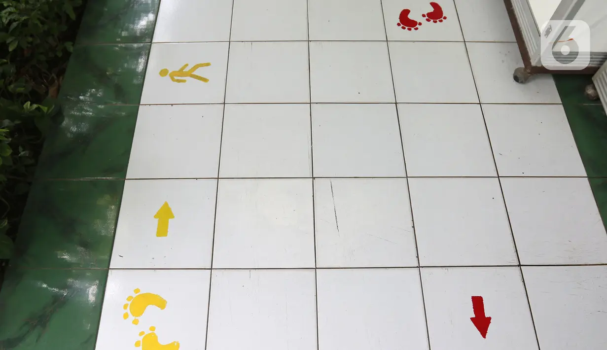 Tanda jaga jarak terpasang jelang dibukanya pembelajaran tatap muka di SMK PB Soedirman 2, Jakarta, Selasa (6/4/2021). Pemprov DKI Jakarta akan melakukan uji coba pembelajaran tatap muka di 100 sekolah mulai 7 April hingga 29 April 2021. (Liputan6.com/Herman Zakharia)