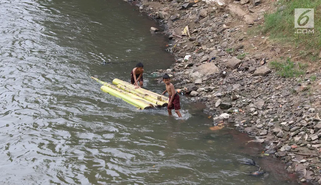 Anak-anak bersiap berenang menggunakan batang pohon pisang di bantaran Sungai Ciliwung, Jakarta, Selasa (15/5). Kurangnya pengawasan menyebabkan anak-anak tersebut bermain tidak pada tempatnya. (Liputan6.com/Immanuel Antonius)