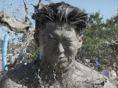 Wajah seorang pria terkena air lumpur selama Festival Lumpur Boryeong di Pantai Daecheon di Boryeong, Korea Selatan, (14/7). Festival lumpur tahunan ke-21 ini menampilkan gulat lumpur. (AP Photo / Ahn Young-joon)
