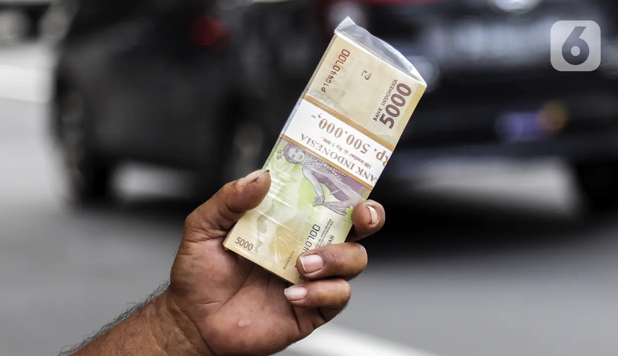 Penjual jasa penukaran uang menawarkan uang baru pecahan Rp 5.000 di kawasan Pondok Indah, Jakarta, Kamis (6/5/2021). Penjual melayani penukaran uang pecahan Rp 2.000, Rp 5.000, Rp 10.000, Rp 20.000, dan Rp 75.000 dalam kondisi baru. (Liputan6.com/Johan Tallo)