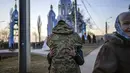 Seorang tentara memeluk kerabat yang melarikan diri dari perang, beberapa menit sebelum berangkat dengan bus menuju Polandia, di Vinnytsia, Ukraina, Rabu, 16 Maret 2022. (AP Photo/Rodrigo Abd)