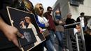 Penggemar membawa foto David Bowie  saat berkumpul di dekat bintang atas nama penyanyi legendaris itu di Hollywood Walk of Fame di Los Angeles, Senin (11/1). Bowie meninggal di usia 69 tahun dan baru saja merilis album ke-25 nya. (REUTERS/ Mario Anzuoni)