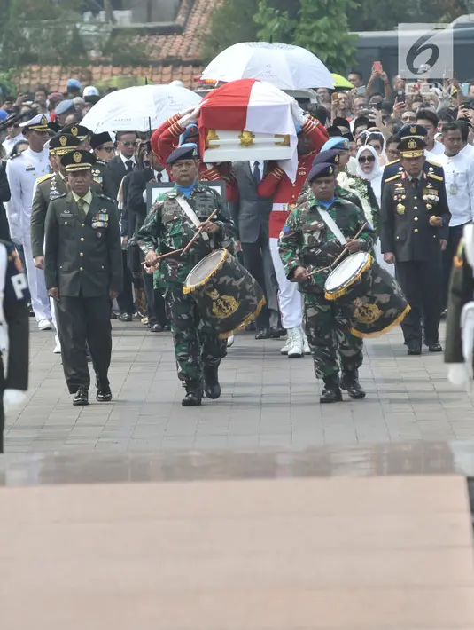 Paspampres mengusung peti jenazah almarhum Presiden ke-3 RI BJ Habibie menuju liang lahat saat tiba di TMP Kalibata, Jakarta, Kamis (12/9/2019). Dimakamkan secara militer, jenazah BJ Habibie diiringi derap marching band dan lantunan kalimat tahlil dari para pelayat. (merdeka.com/Iqbal Nugroho)
