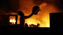 Seorang pria berusaha menyiramkan air saat kebakaran di lingkungan Educandos, di Manaus, Brasil (17/12). Kebakaran diduga disebabkan oleh ledakan panci presto yang menghanguskan ratusan rumah warga. (AP Photo/Edmar Barros)