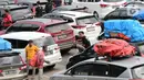 <p>Pemudik keluar dari kendaraannya untuk beristirahat saat berada di Pelabuhan Merak, Banten, Jumat (29/4/2022). Banyak pemudik yang memanfaatkan waktu sebelum masuk kapal dengan beristirahat di area dermaga setelah mereka terjebak macet hingga berjam-jam. (Liputan6.com/Angga Yuniar)</p>