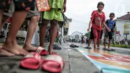 Anak-anak bermain permainan tradisional di kawasan Kota Tua, Jakarta Barat, Minggu (13/11/2022). Ada sembilan jenis permainan tradisional yang dihadirkan seperti rangku alu, gasing, kapal otok-otok, engklek, lompat tali, congklak, petak umpet, petak jongkok, dan bola bekel. (merdeka.com/Iqbal S. Nugroho)