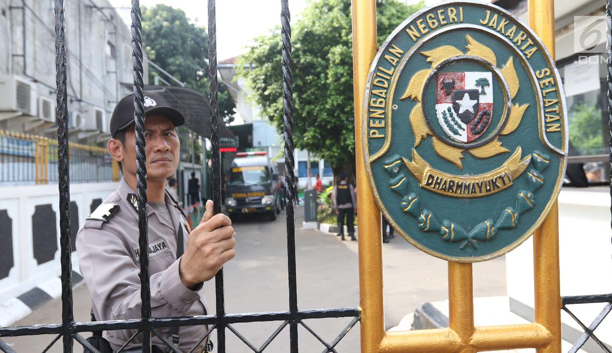 Personel kepolisian melakukan penjagaan di gerbang masuk Pengadilan Negeri Jakarta Selatan pada sidang pembacaan vonis terdakwa terorisme Aman Abdurrahman, Jumat (22/6). Polisi juga menyiagakan penembak jitu di beberapa titik. (Liputan6.com/Angga Yuniar)