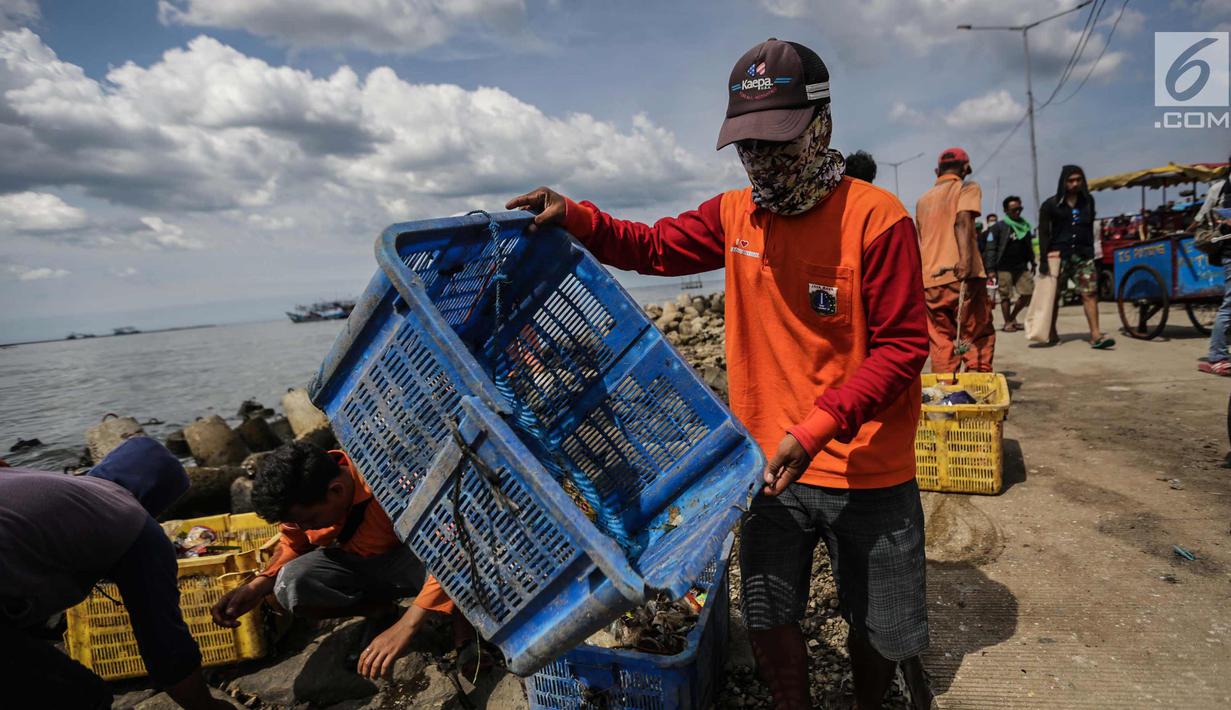 Petugas kebersihan membawa sampah  laut di Pelabuhan Kali Adem, Jakarta, Senin (1/1). Banyaknya sampah plastik dibandingkan ikan yang gagal dikelola dengan baik membuat limbah yang mengakibatkan laut tercemar. (Liputan6.com/Faizal Fanani)