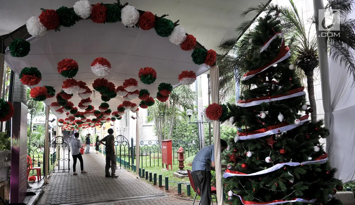 Panitia menyelesaikan pemasangan pohon Natal dan ornamen lainnya saat mendekorasi kompleks Gereja Katedral, Jakarta, Minggu (23/12). Gereja Katedral mengusung tema 'Persatuan Indonesia' dalam perayaan Natal tahun ini. (Merdeka.com/Iqbal S Nugroho)