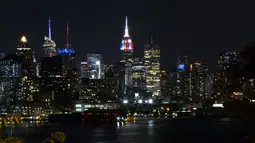 Gedung pencakar langit Empire State di New York memancarkan lampu warna bendera juara Piala Dunia 2018, Prancis, Minggu (15/7). Sebelumnya, pucak gedung terkenal di Amerika Serikat itu selalu menyalakan warna putih. (AFP PHOTO / KENA BETANCUR)