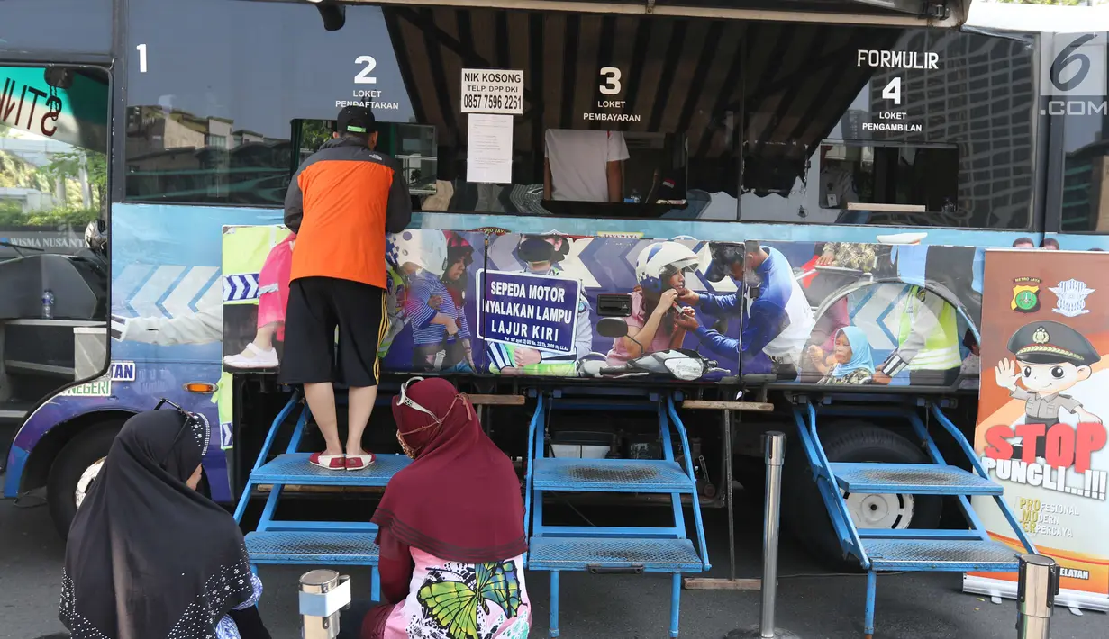 Warga membayar pajak kendaraan bermotor di gerai Samsat Keliling Car Free Day, Jakarta, Minggu (21/10). Agar bisa membayar pajak ini cukup menggunakan STNK dengan nama yang tertera harus sesuai KTP. (Liputan6.com/Angga Yuniar)