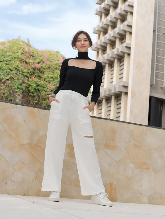 <p>Bila tidak percaya diri menggunakan warna cerah, padukan celana putihmu dengan atasan warna gelap. Kamu bisa gunakan celana putih model lebar dan atasan yang fit in body untuk memberi tampilan gothic. [Instagram/nanamirdad_] Penulis: Mufiidaanaiilaa Alifah S.</p>