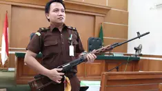 Jaksa Penuntut Umum menunjukkan barang bukti senapan milik bos First Travel di PN Kota Depok, Senin (23/4). Sidang lanjutan First Travel tersebut beragendakan pemeriksaan ketiga terdakwa. (Liputan6.com/Herman Zakharia)