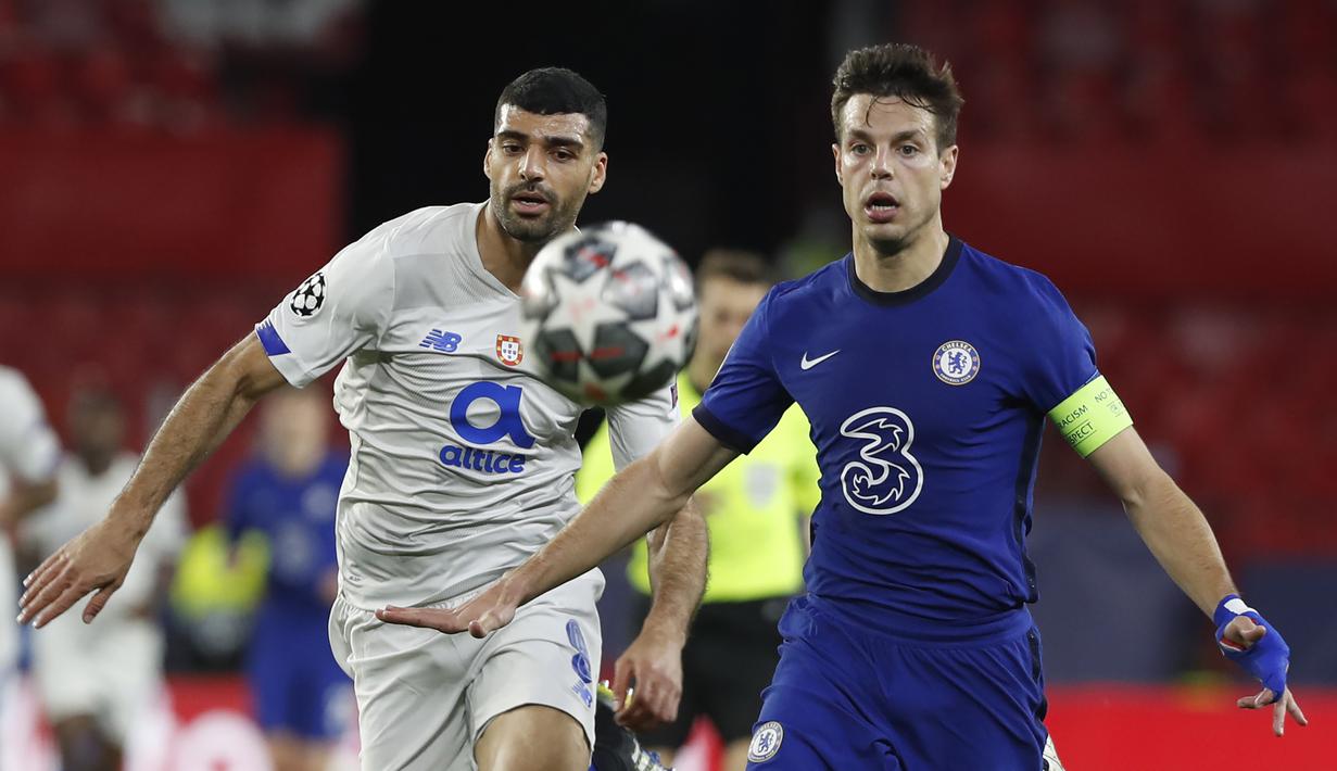 Bek Chelsea, Cesar Azpilicueta (kanan) berebut bola dengan striker Porto, Mehdi Taremi dalam laga leg kedua perempatfinal Liga Champions 2020/2021 di Ramon Sanchez Pizjuan Stadium, Sevilla, Selasa (13/4/2021). Chelsea kalah 0-1 dari Porto. (AP/Angel Fernandez)