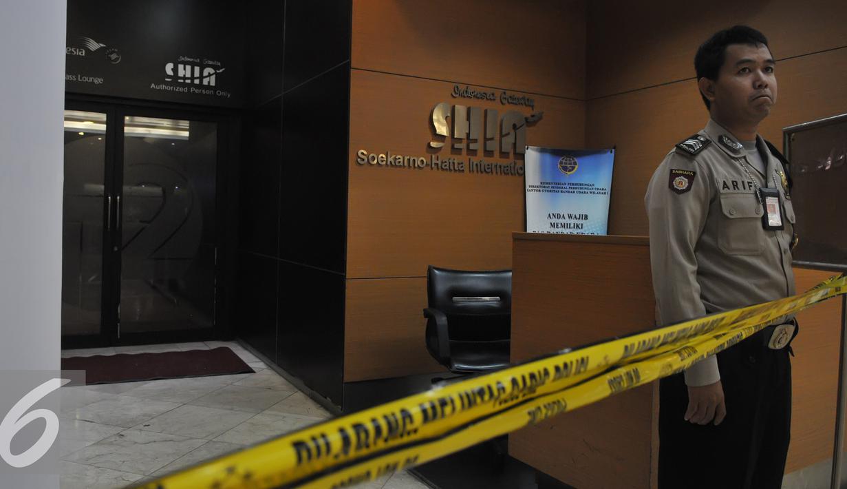 Petugas polisi masih berjaga pasca kebakaran di Terminal 2E Bandara Soekarno Hatta, Tangerang, Senin (6/7/2015). Pasca insiden kebakaran pada Minggu (5/6) lalu, jadwal penerbangan mulai normal. (Liputan6.com/Herman Zakharia)