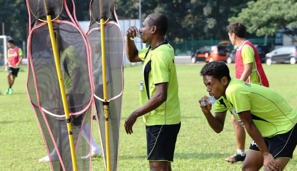 Yustinus Pae (kiri) dan Yohanis Tjoe berteduh dari sengatan matahari saat jeda latihan. (bola.com/Arief Bagus)