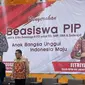 Politikus PDI Perjuangan (PDIP) Eriko Sotarduga dan Fitriyah menyerahkan beasiswa Program Indonesia Pintar (PIP) untuk anak SD, SMP, dan SMA/Sederajat. (Foto: Istimewa).