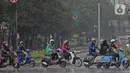 Pengendara sepeda motor menggunakan jas hujan saat berkendara di kawasan Bundaran HI, Jakarta, Minggu (24/1/2021). Badan Meteorologi Klimatologi dan Geofisika (BMKG) mencatat sebagian besar wilayah Indonesia telah memasuki masa puncak musim hujan. (Liputan6.com/Herman Zakharia)