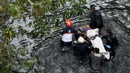 Petugas membawa tandu yang berisi korban jatuhnya bus ke jurang  dari sebuah jembatan di Negara Bagian Veracruz, selatan Meksiko, Minggu (10/1). Sedikitnya 20 orang penumpang tewas dalam kecelakaan ini. (REUTERS/Yahir Ceballos)