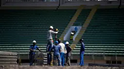 Pekerja memulai pembangunan rumah sakit darurat bagi pasien terinfeksi Covid-19 di kompleks stadion Maracana, Rio de Janeiro, Kamis (2/4/2020). Sebagian kompleks stadion paling terkenal di Brasil itu diubah menjadi rumah sakit lapangan selama pandemi Covid-19. (MAURO PIMENTEL/AFP)