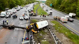 Personel darurat memeriksa kondisi bus sekolah yang bertabrakan dengan truk sampah di Interstate 80, Mount Olive, New Jersey, Kamis (17/5). Ada 45 orang berada di dalam bus, yakni tujuh orang dewasa dan 38 siswa. (Bob Karp/The Daily Record via AP)