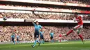 Aksi Mesut Ozil (kanan) mencetak gol saat Arsenal menang atas  Swansea City 3-2 pada laga Premier League pekan ke-8 di Emirates Stadium, London (15/10/2016). (AFP/Justin Tallis)