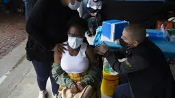 Seorang perempuan muda disuntik vaksin COVID-19 di sebuah lokasi dekat Johannesburg, Rabu (8/12/2021). Kasus Omicron telah dikonfirmasi setidaknya di sembilan negara Afrika, dengan Afrika Selatan tetap menjadi episenter awal ditemukannya varian baru tersebut. (AP Photo/Denis Farrell)