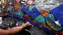 Gonzalo Duran menyusun pecahan keramik menjadi mozaik di salah satu sudut Mosaic Tile House Venice, California, AS, (26/9). Rumah ini merupakan karya pasangan suami istri, Gonzalo Duran dan Cheri Pann. (REUTERS/Mario Anzuoni)