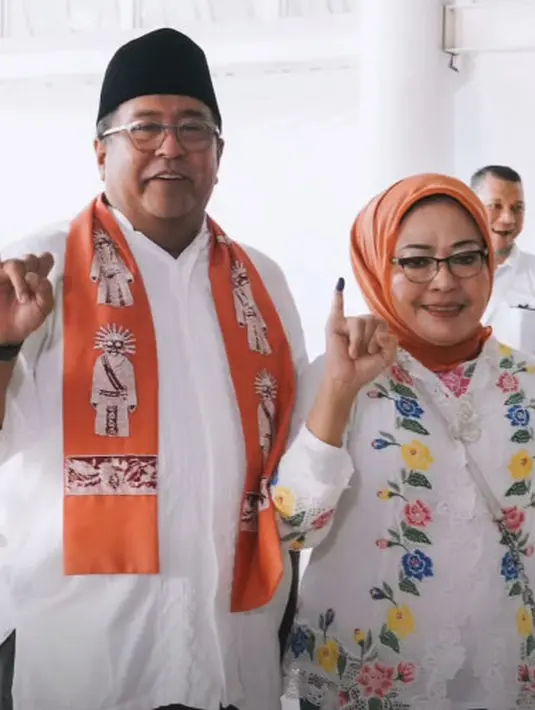 Rano Karno dan sang istri nyoblos di TPS Lebak Bulus dengan serba putih. Rano Karno kenakan kemeja putih dan selempang ondel-ondel. Sedangkan Dewi Indriati kenakan kebaya encim putih floral dan hijab oranye [@si.rano]