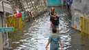 Warga melawati jalanan yang banjir di kawasan Jakarta Barat, Jumat (26/2). Banjir terjadi juga dikarenakan kali Daan Mogot yang  tak kunjung surut. (Liputan6.com/Faisal R Syam)