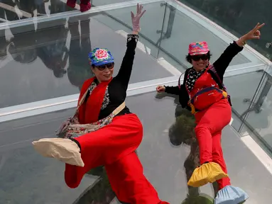 Dua turis berselfie saat mengunjungi wahana platform kaca di Shilin Gorge, Beijing, Cina, (27/5). Platform kaca ini merupakan yang terpanjang di dunia mengalahkan Grand Canyon. (REUTERS/Kim Kyung-Hoon)