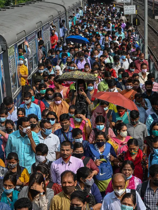 Komuter memadati peron kereta api di Kolkata, India, Senin (1/11/2021). Layanan kereta api kembali normal setelah menerapkan pembatasan yang diberlakukan sebelumnya untuk mengekang penyebaran corona Covid-19. (DIBYANGSHU SARKAR/AFP)