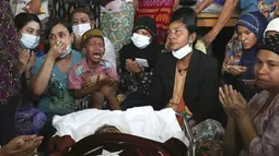 Anggota keluarga dan kerabat berdoa di samping jenazah wanita Muslim yang menurut keluarganya dibunuh oleh tentara hari Minggu saat ikut demonstras menentang kudeta militer Myanmar, saat upacara pemakamannya di Mandalay, Myanmar, Senin (1/3/2021). (AP Photo)